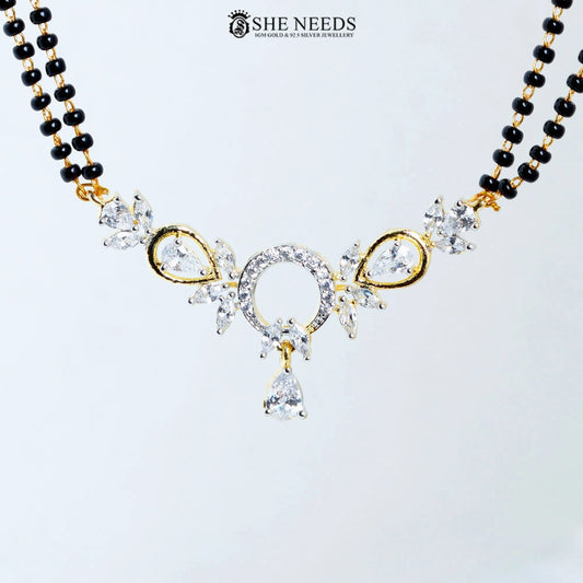 Close-up of Anvika Gold Plated AD Halo Mangalsutra featuring a sparkling halo-style American Diamond pendant with pear-cut CZ stones, floral accents, and black bead chain.|She Needs Jewellery