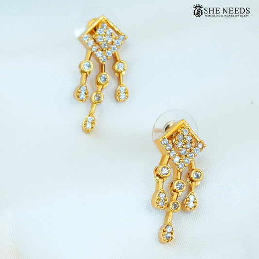 Close-up of geometric gold earrings with diamond-studded detailing and multiple dangling accents|She Needs Jewellery