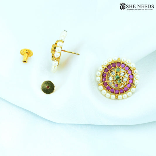 Side view of Ratnashri Antique Gold Pearl Floral Stud Earrings showcasing pearl border, ruby-colored stones, emerald-colored stones and American Diamonds.|She Needs Jewellery