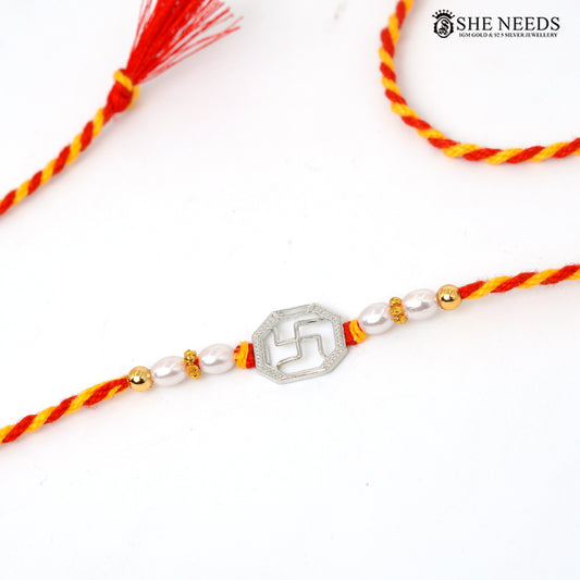 Swastik 925 silver Rakhi with pearl beads and red-yellow thread styled in a festive Raksha Bandhan setting|She Needs Jewellery