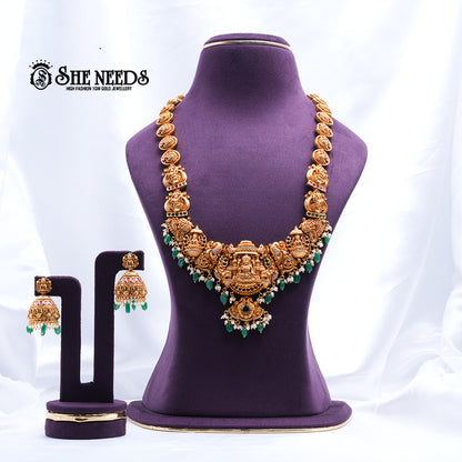Antique Gold Lakshmi Temple Necklace Set featuring Lakshmi motifs, green bead drops, AD stones, and matching temple jhumka earrings | She Needs Jewellery