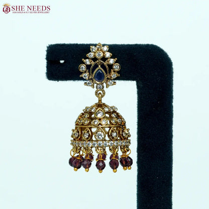 Antique gold-plated jhumka earrings with white zircon stones and purple bead drops for women.|She Needs Jewellery
|She Needs Jewellery
