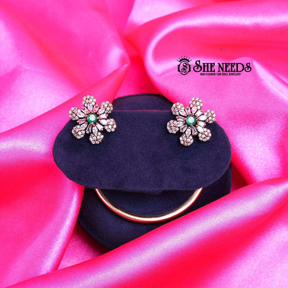 Antique gold daisy stud earrings featuring sparkling CZ stones and a soft light green center stone in a floral design.|She Needs Jewellery

