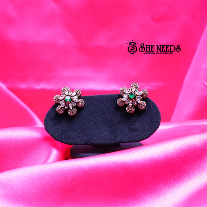Antique gold daisy stud earrings featuring sparkling CZ stones and a soft light green center stone in a floral design.|She Needs Jewellery
