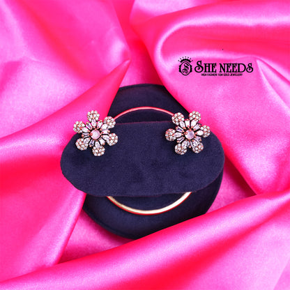 Antique gold daisy stud earrings featuring sparkling CZ stones and a delicate light pink center stone in a floral design.|She Needs Jewellery
