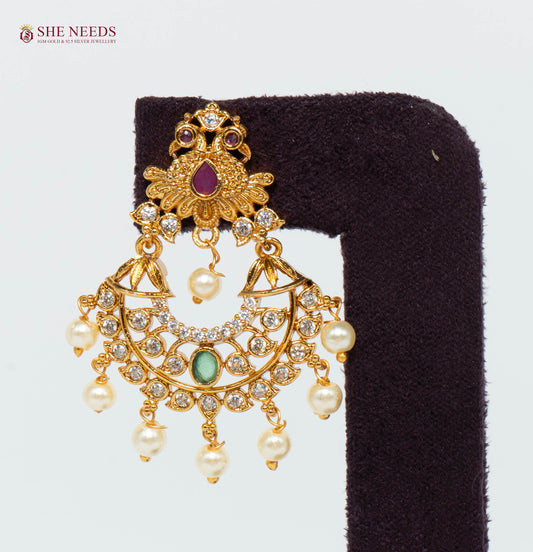 Antique Peacock Chandbali Earring featuring American Diamond (CZ) stones, ruby and green accents, pearl drops, and an antique gold finish | She Needs Jewellery
