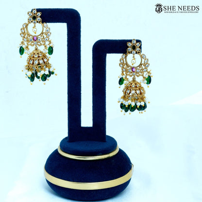 Pair of Chandrika Antique Gold Crescent Temple Jhumka Earrings featuring floral studs, crescent motifs, American Diamonds, ruby-colored stones, pearl accents, and green bead drops.|She Needs Jewellery
