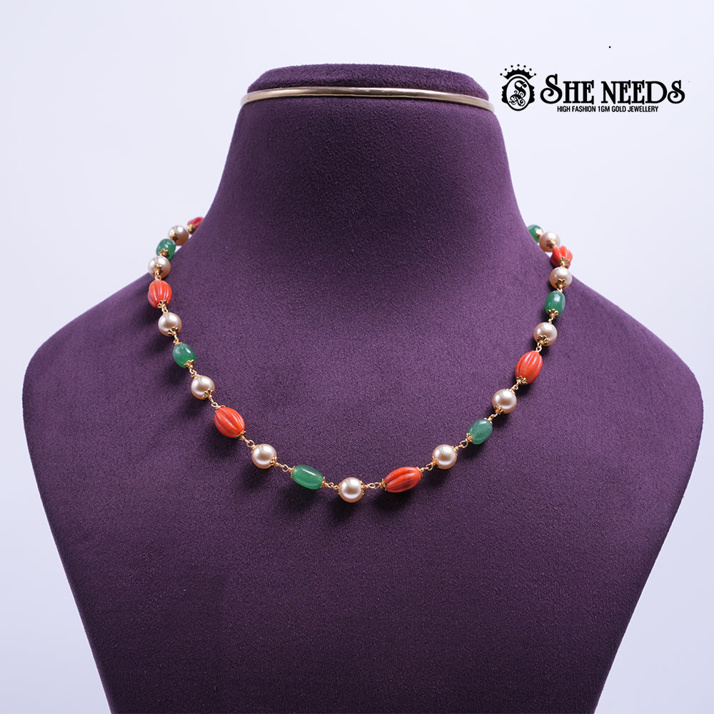 Coral & Emerald Pearl Harmony Necklace featuring coral-red textured beads, emerald-green beads, pearl accents, and decorative gold-tone detailing.|She Needs Jewellery

