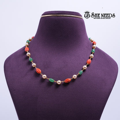 Coral & Emerald Pearl Harmony Necklace featuring coral-red textured beads, emerald-green beads, pearl accents, and decorative gold-tone detailing.|She Needs Jewellery
