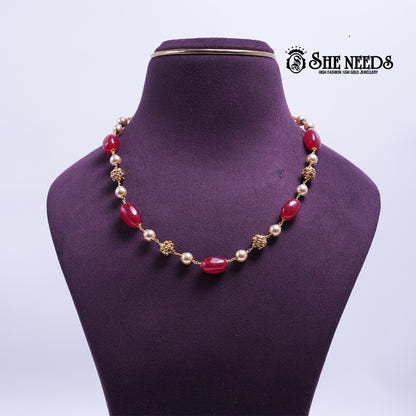 Crimson Glow Pearl Necklace featuring crimson-red oval beads, pearl accents, and decorative gold-tone spacers in an elegant handcrafted design.|She Needs Jewellery
