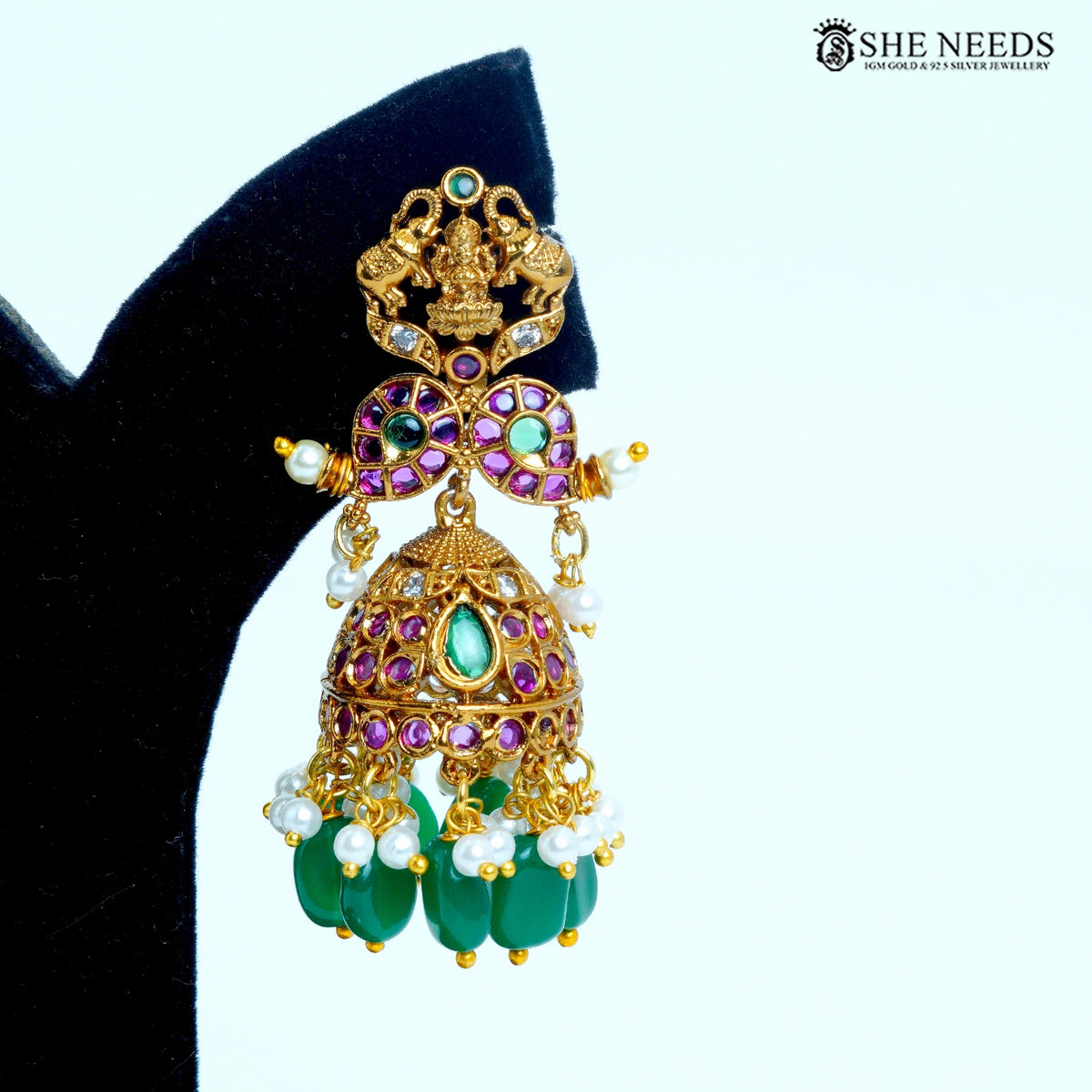 Devika temple dome jhumka earring featuring green and pink stones, white pearls and gold polish|She Needs Jewellery
