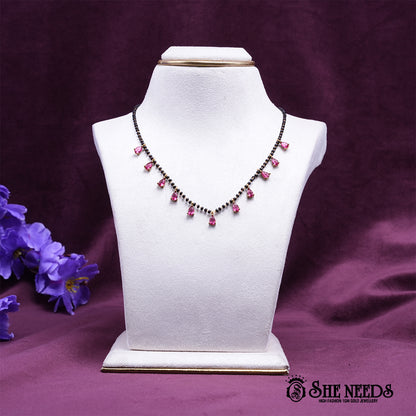 Black bead mangalsutra necklace featuring elegant pink pear-shaped stone drops set in a gold-tone finish.|She Needs Jewellery

