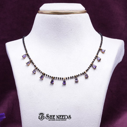 Black bead mangalsutra necklace featuring graceful purple pear-shaped stone drops set in a gold-tone finish.|She Needs Jewellery
