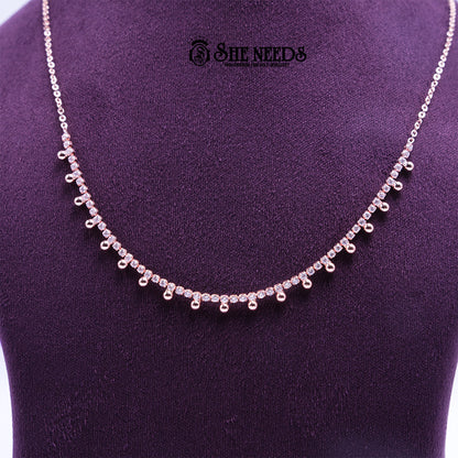 Rose gold Droplet Grace necklace featuring sparkling CZ stones and delicate droplet-shaped danglers arranged along a fine chain, displayed on a purple jewelry bust. |She Needs Jewellery