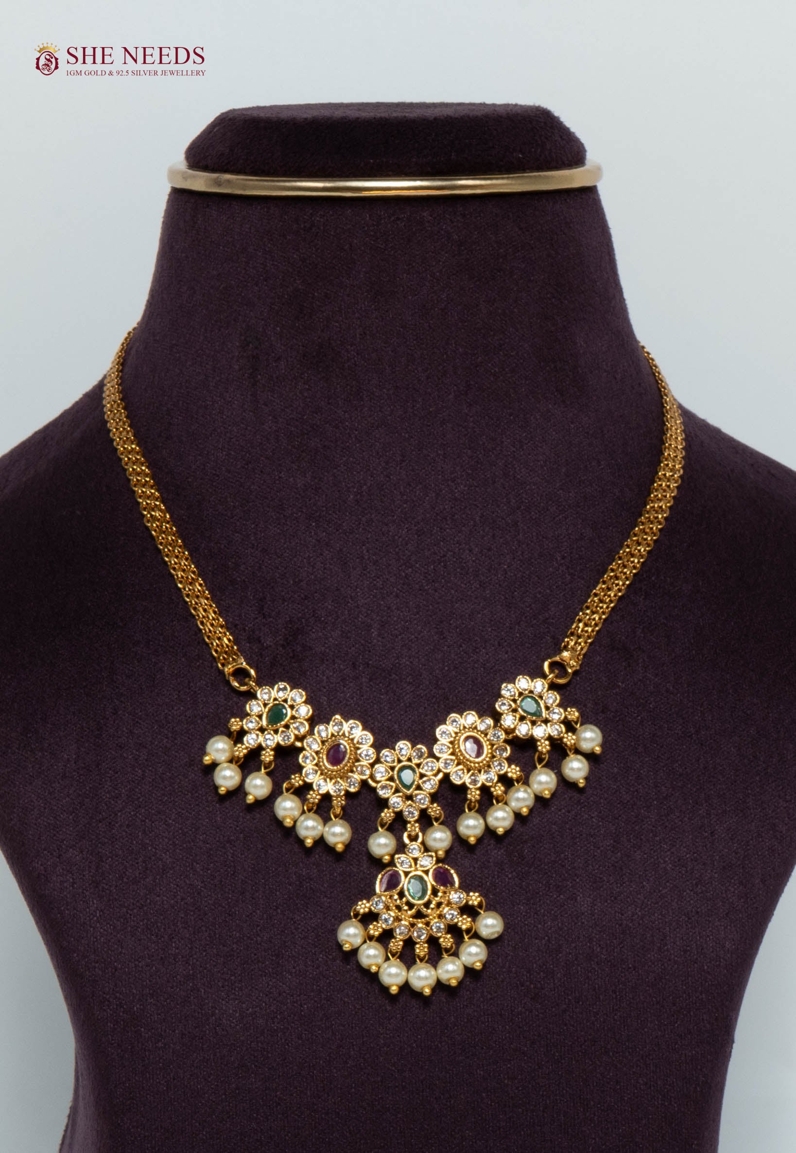 Gold-plated floral cascade necklace featuring pink and green stones, sparkling American Diamonds, pearl drops, and an elegant traditional pendant design for women.|She Needs Jewellery
