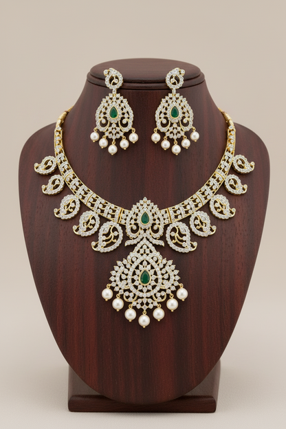Traditional emerald green AD stone necklace set with pearl drop earrings in premium gold finish displayed on mannequin.