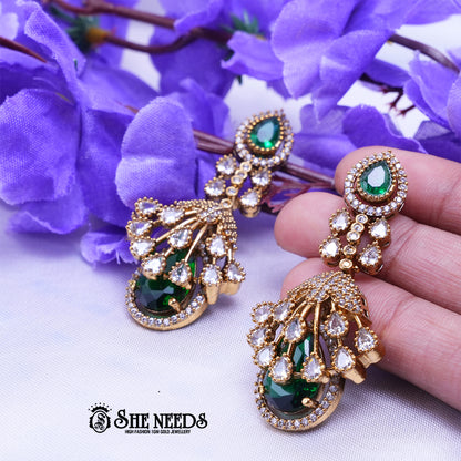 Elegant emerald green long drop earrings with American diamonds and gold polish from She Needs Jewellery