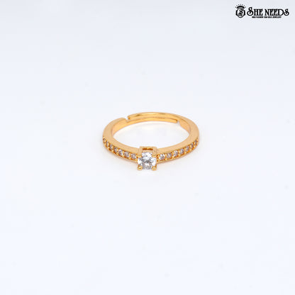 Gold-plated adjustable solitaire ring featuring a round-cut cubic zirconia center stone and pavé-set CZ stones on the band against a white background |She Needs Jewellery