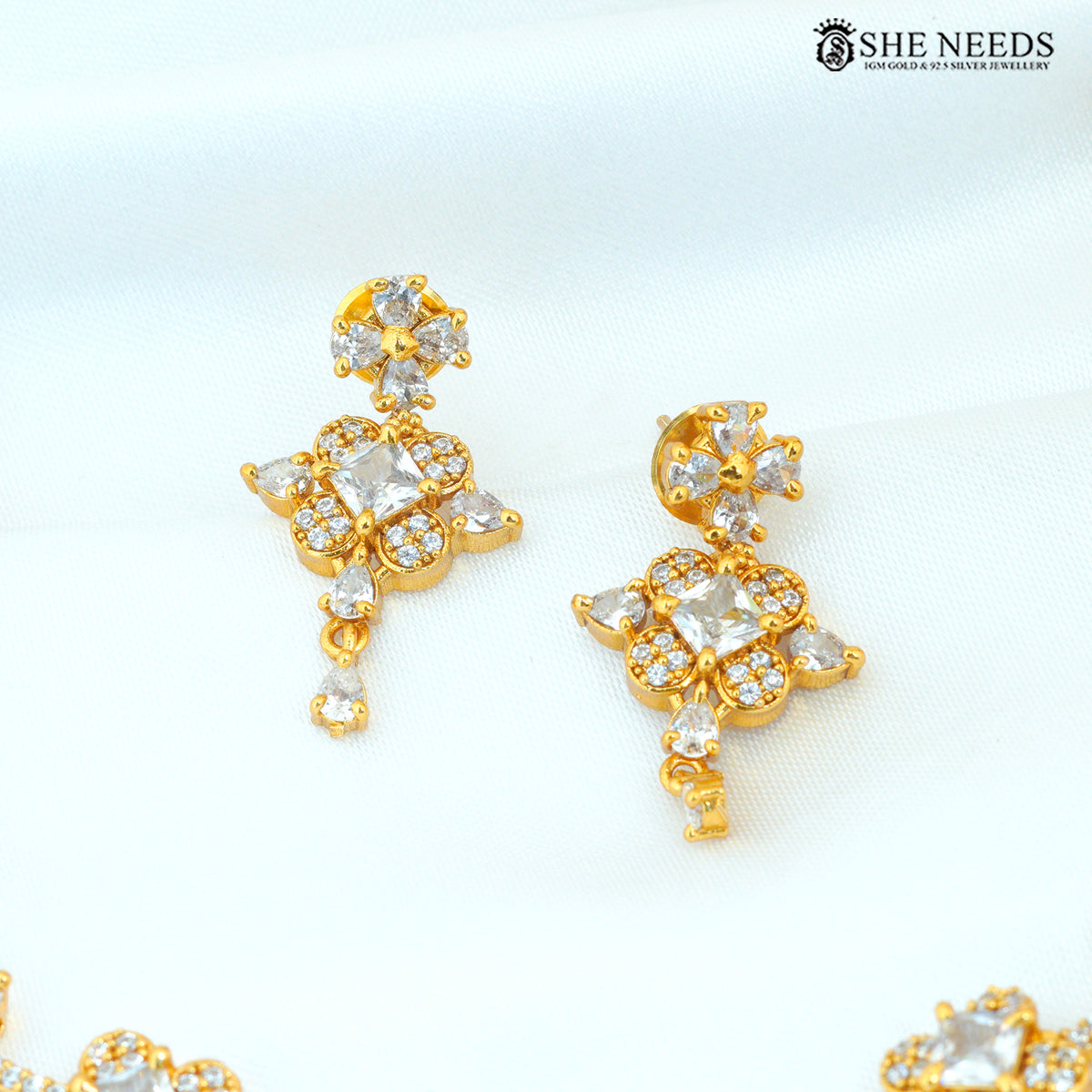 Gold polish floral American Diamond drop earrings with sparkling white stone detailing|She Needs Jewellery
