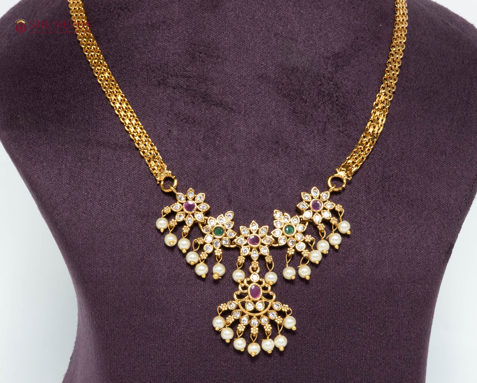Gold-plated floral pendant necklace featuring pink and green stones, American Diamonds, pearl drops, and an elegant traditional design for women.|She Needs Jewellery
