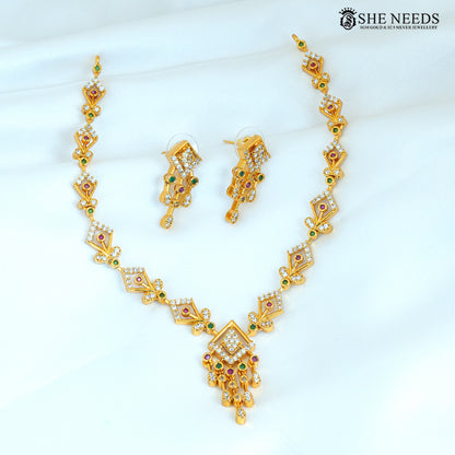 Geometric gold necklace set with matching earrings featuring ruby, green and white stones and a statement pendant
|She Needs Jewellery