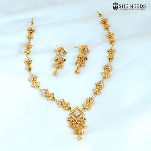 Geometric gold necklace set with matching earrings featuring ruby, green and white stones and a statement pendant
|She Needs Jewellery