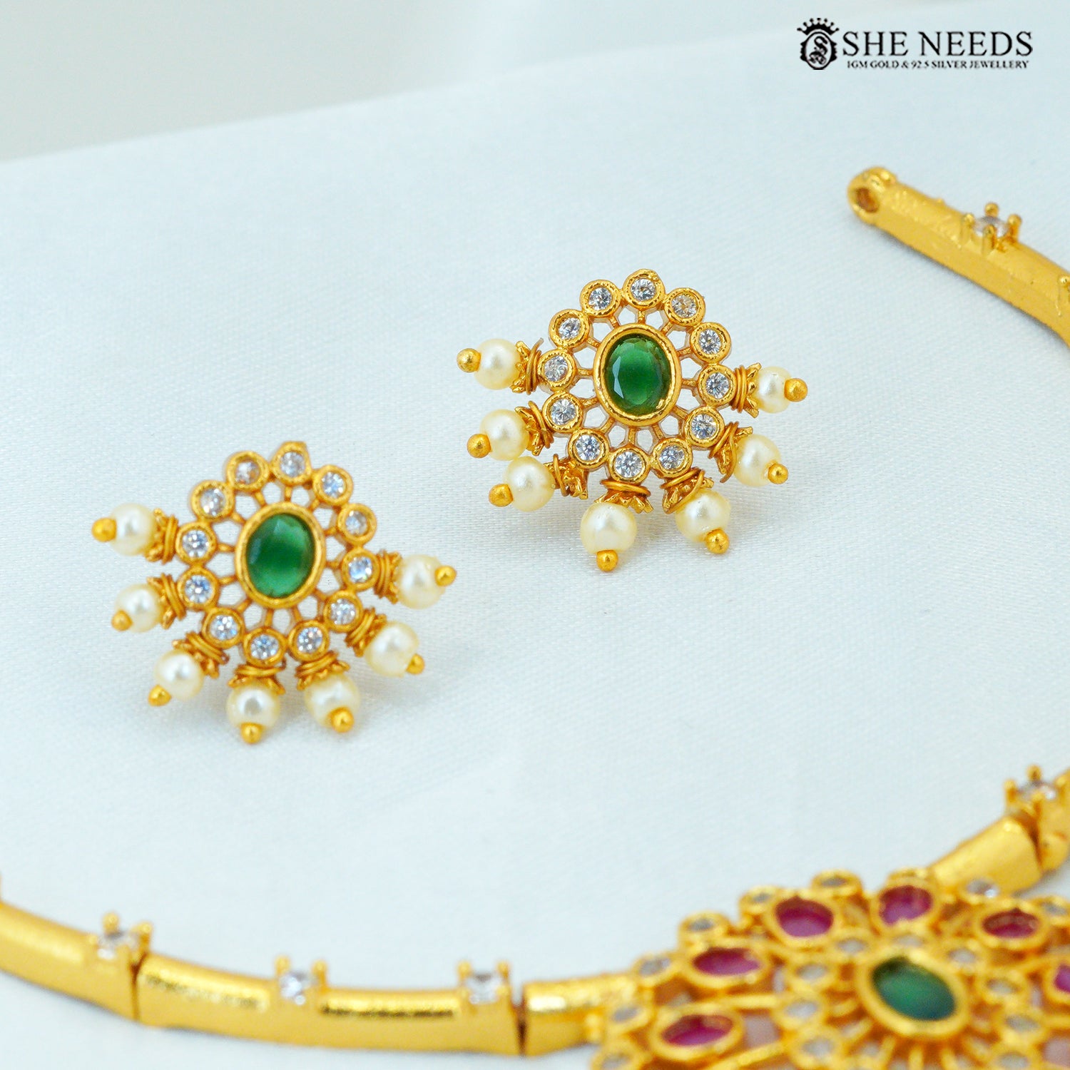 Gold-plated green stone ruby-tone drop earrings with American Diamond stones and pearl detailing|She Needs Jewellery

