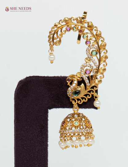 Gold-plated peacock ear cuff jhumka earring featuring American Diamonds, multicolor stones, intricate filigree detailing, and pearl drop danglers for bridal and festive wear.|She Needs Jewellery
