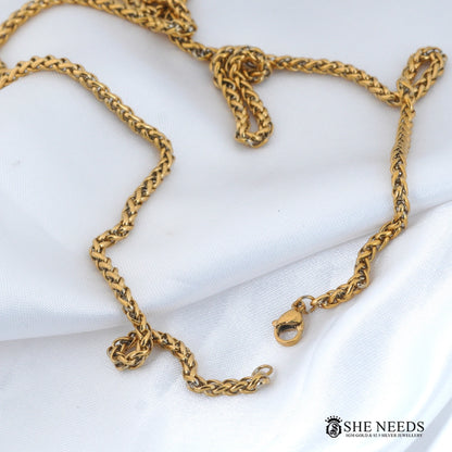 Gold finish men's chain necklace featuring a stylish braided link design, secure clasp closure, and premium polished finish displayed on a white fabric background.