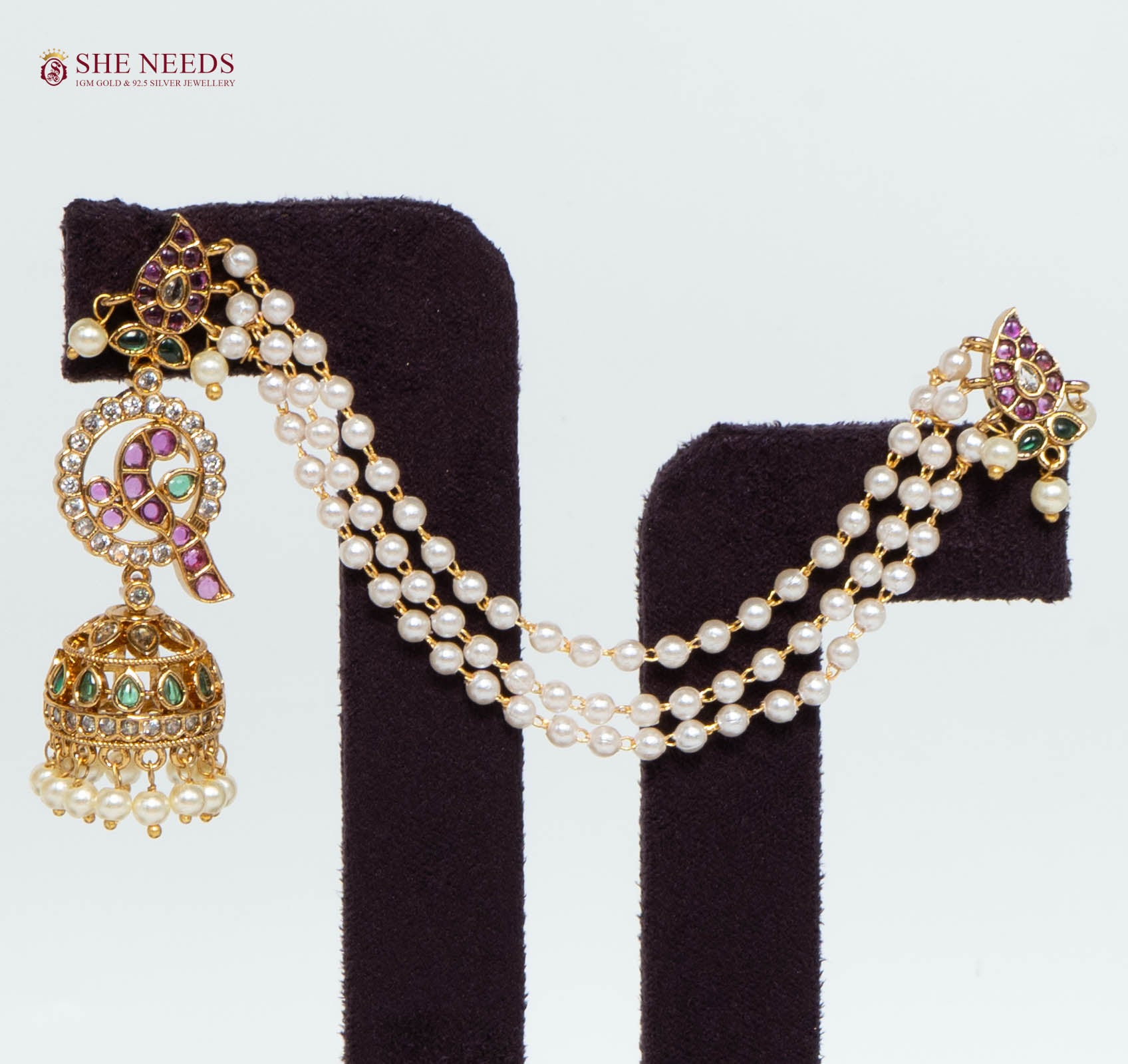 Single gold multicolor ear cuff jhumka earring featuring triple white pearl chains, pink and green stones, American Diamond (AD) stones, and pearl drop jhumka.|She Needs Jewellery
