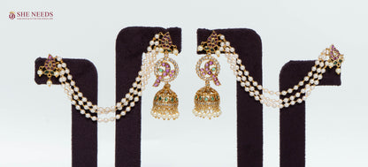 Gold multicolor ear cuff jhumka earrings with triple white pearl chains, pink and green stones, American Diamond stones, and pearl drop jhumkas displayed as a pair.|She Needs Jewellery
