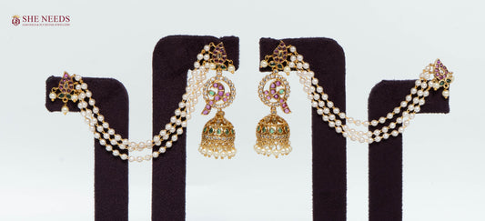 Gold multicolor ear cuff jhumka earrings with triple white pearl chains, pink and green stones, American Diamond stones, and pearl drop jhumkas displayed as a pair.|She Needs Jewellery
