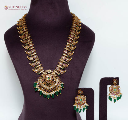 Gold multicolor temple pendant necklace set with American Diamond stones, green bead drops, pearl detailing, and matching earrings.|She Needs Jewellery
