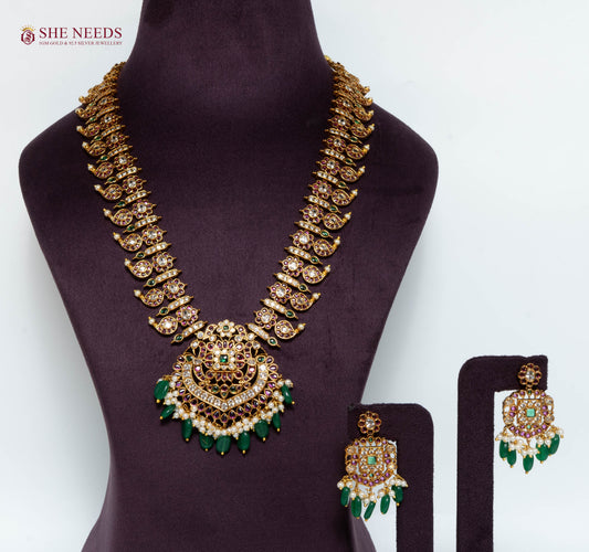 Gold multicolor temple pendant necklace set with American Diamond stones, green bead drops, pearl detailing, and matching earrings.|She Needs Jewellery
