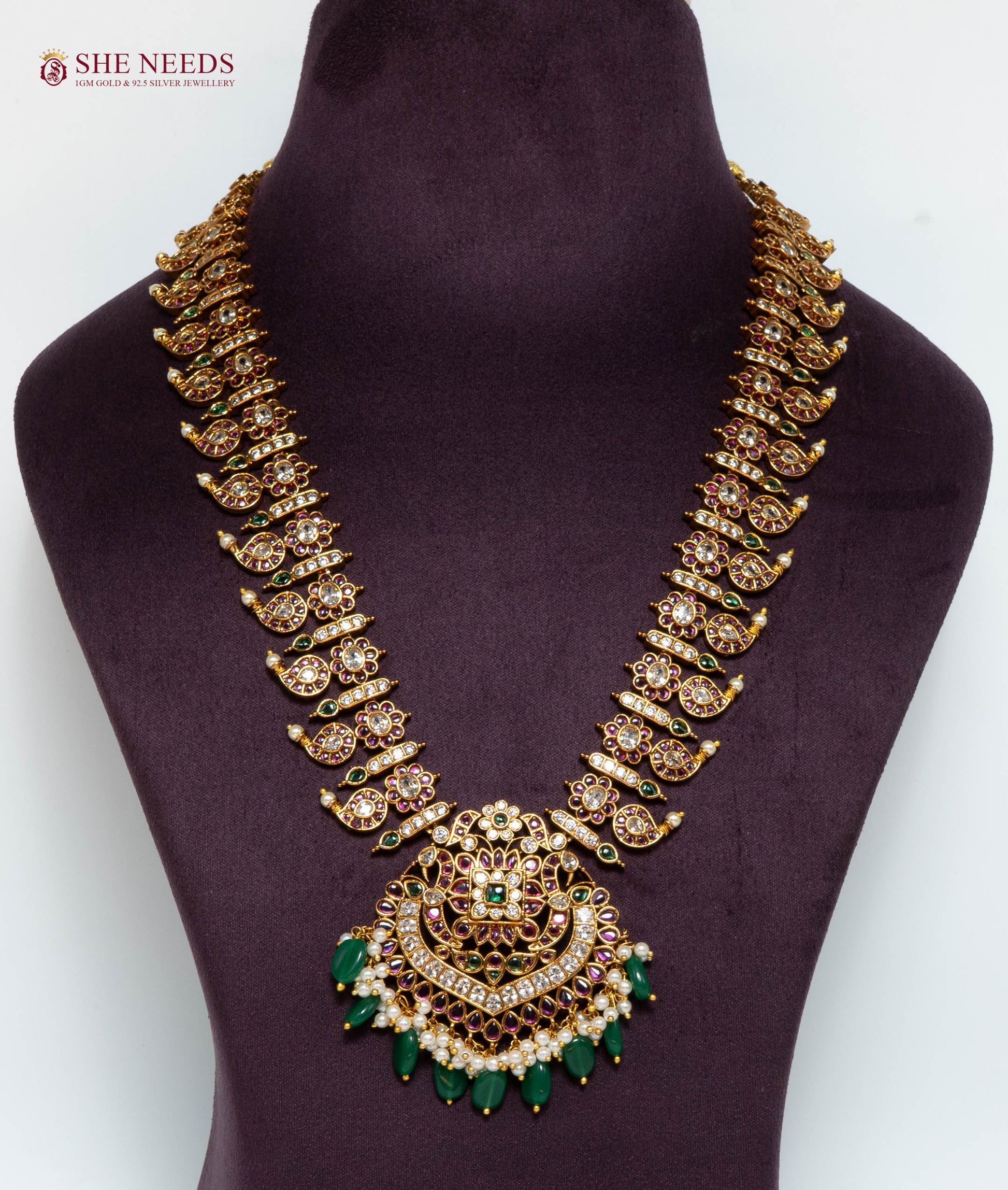 Gold multicolor temple pendant necklace featuring American Diamond stones, green bead drops, pink stones, and pearl accents.|She Needs Jewellery
