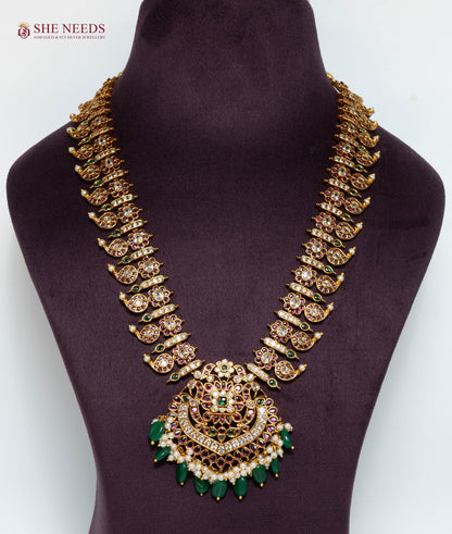 Gold multicolor temple pendant necklace featuring American Diamond stones, green bead drops, pink stones, and pearl accents.|She Needs Jewellery
