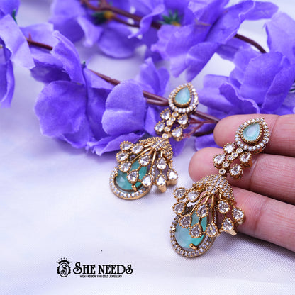 Gold Plated American Diamond Light Blue Statement Drop Earrings featuring sparkling CZ stones and elegant light blue teardrop stones with a premium gold finish | She Needs Jewellery