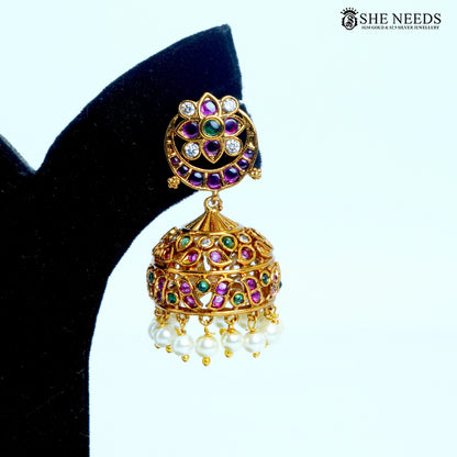 Ishani floral dome jhumka earring with pink and green stones, white sparkling accents and pearl drops in gold-tone finish|She Needs Jewellery
