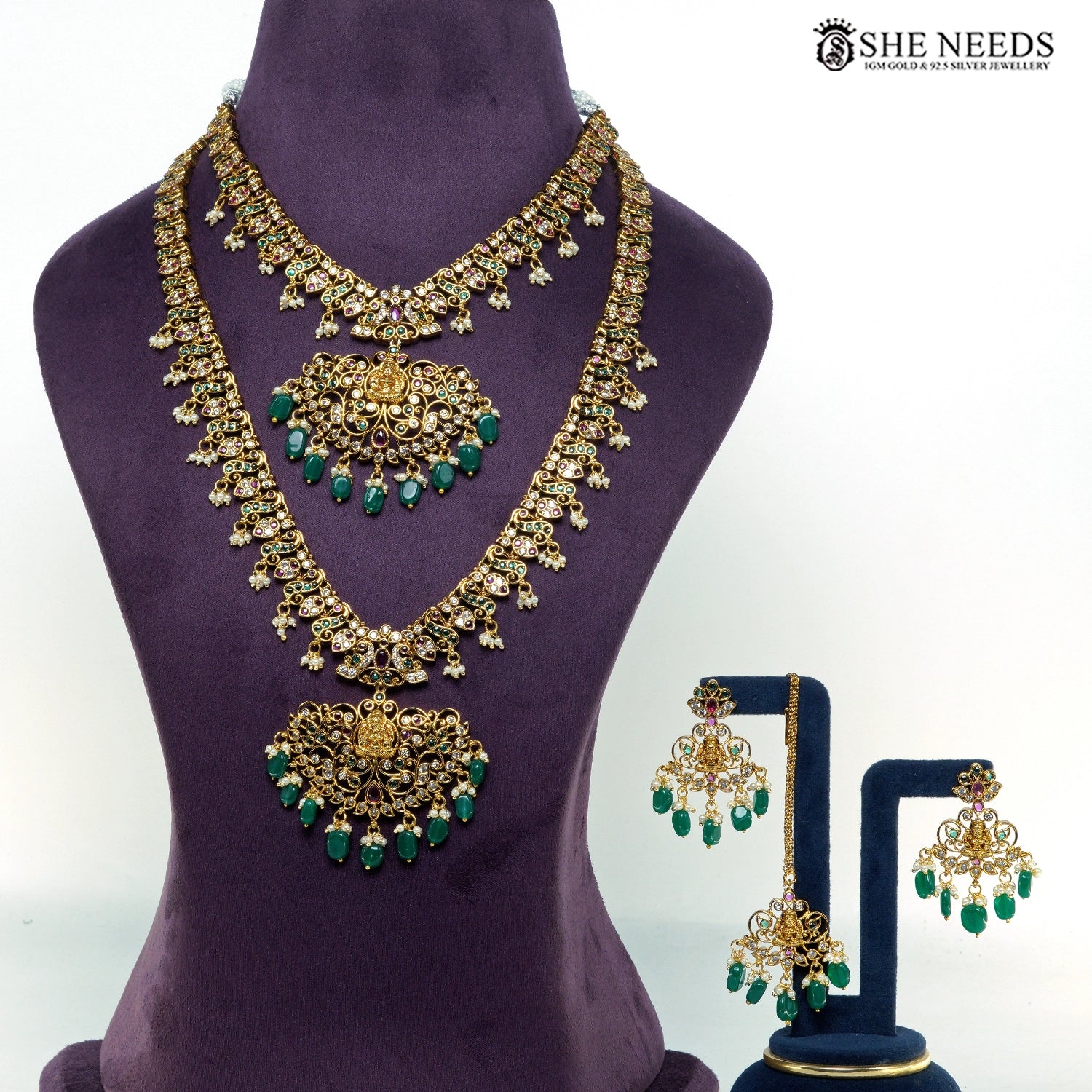 Lakshmi temple jewellery set with layered gold-plated necklaces, green bead drops, ruby-tone stones, pearl accents and matching earrings|She Needs Jewellery
