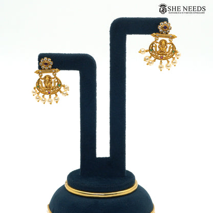Matching Lakshmi motif earrings with ruby and green stones and pearl drop detailing|She Needs Jewellery
