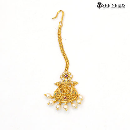 Traditional Lakshmi maang tikka with ruby and green stone accents and pearl drops|She Needs Jewellery
