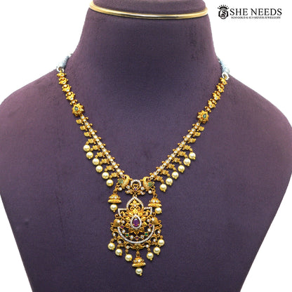 Close-up of antique gold Lakshmi temple necklace with detailed pendant, AD stones and pearl accents|She Needs Jewellery
