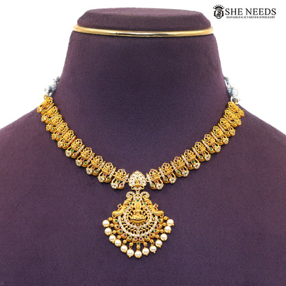 Close-up of antique gold Lakshmi necklace with detailed Goddess Lakshmi pendant, AD stones and pearl drops|She Needs Jewellery
