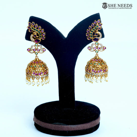 Mayura Royale peacock curve jhumka earring featuring pink and green stones, white detailing and pearl drops in gold-tone finish|She Needs Jewellery
