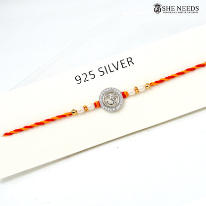 Om Radiance 925 silver Rakhi with pearl beads, sparkling stones and red-yellow braided thread|She Needs Jewellery
