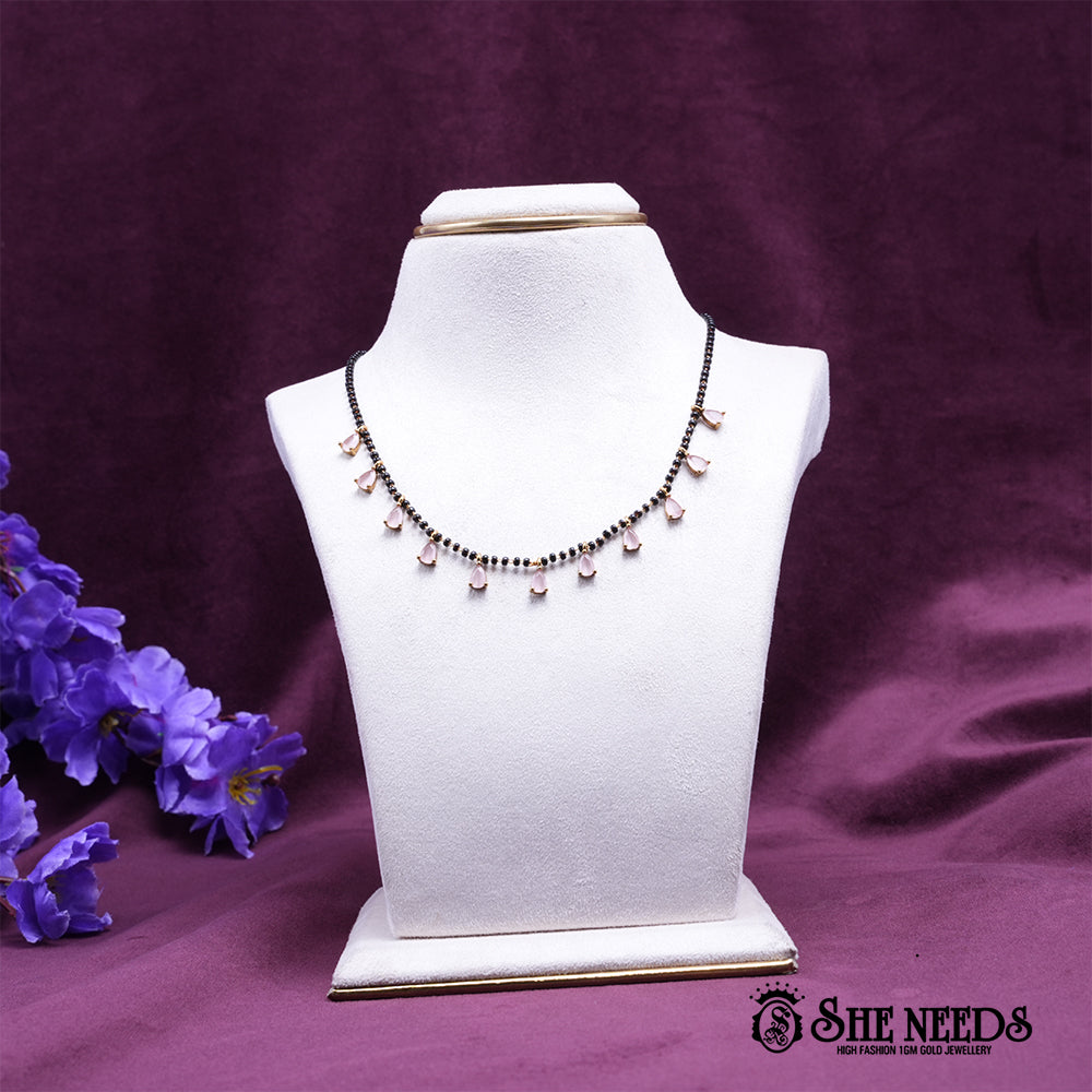 Short black bead mangalsutra-style necklace with dangling green teardrop stones.