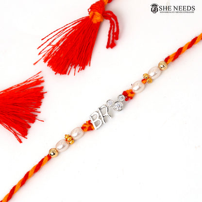 925 silver Rakhi with red and yellow braided thread, pearl beads, sparkling stones and BRO center charm.