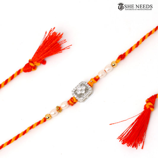 Elegant silver Rakhi with pearl beads, sparkling CZ stones and red-yellow braided thread for Raksha Bandhan.