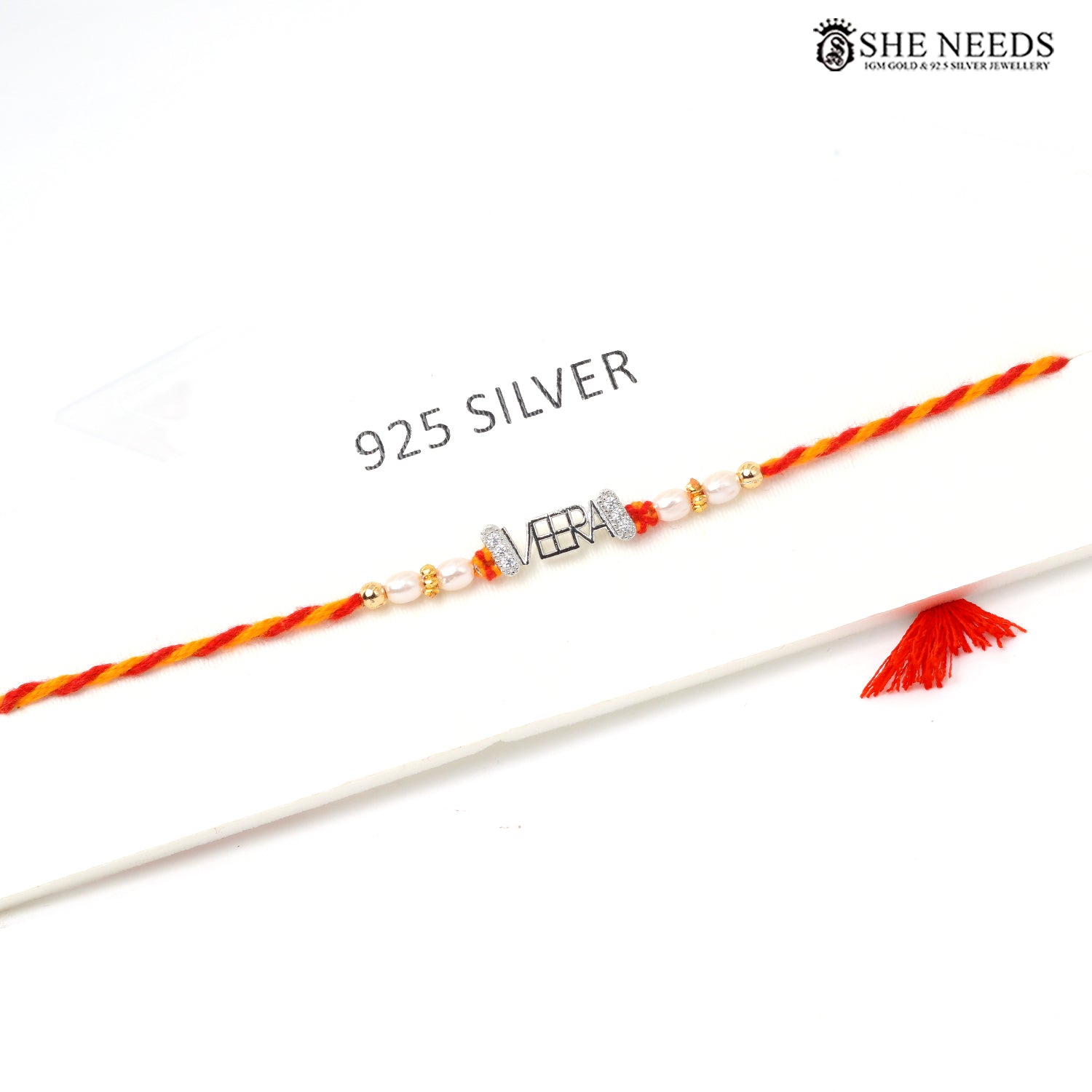 925 silver VEERA name Rakhi with pearl beads, sparkling stone accents and red-yellow braided thread.
