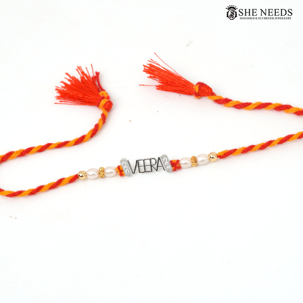 925 silver VEERA name Rakhi with pearl beads, sparkling stone accents and red-yellow braided thread.